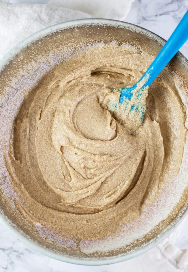 Brown sugar, butter, and eggs creamed in ceramic bowl.