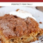 Slice of gluten free apple cake on white plate with fork topped with whipped cream.