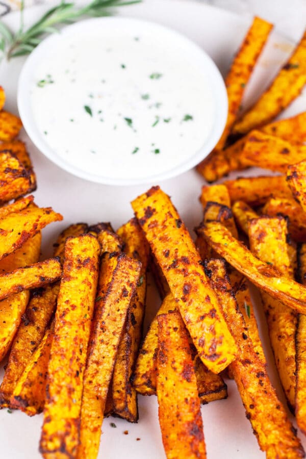 Butternut squash fries and rosemary dipping sauce on round platter.