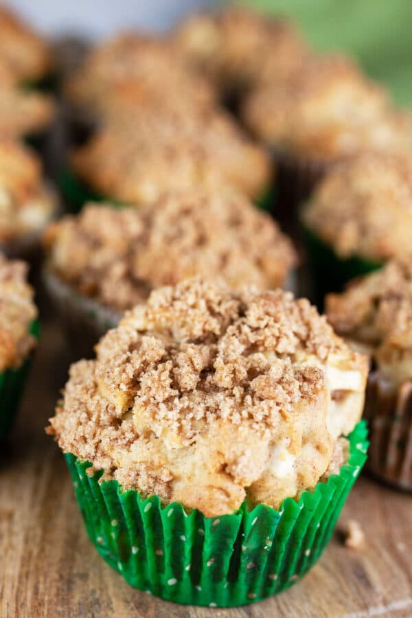 Baked apple streusel muffins on wooden board.