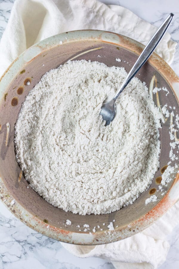 Dry apple muffin ingredients combined in ceramic bowl.