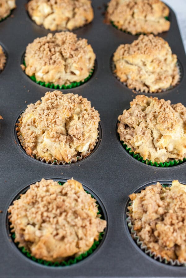 Baked apple streusel muffins in muffin tin.