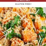 Butternut squash quinoa kale salad garnished with Parmesan cheese and lemon wedge.