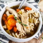 Gluten free chicken noodle soup in small white bowl.