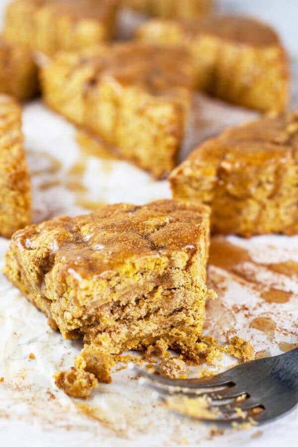 Piece of maple glazed gluten free pumpkin scones cut with fork.