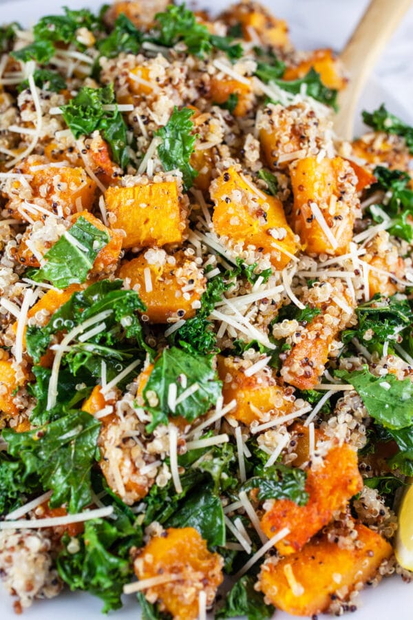 Butternut squash, kale, and quinoa salad with Parmesan cheese on serving platter.