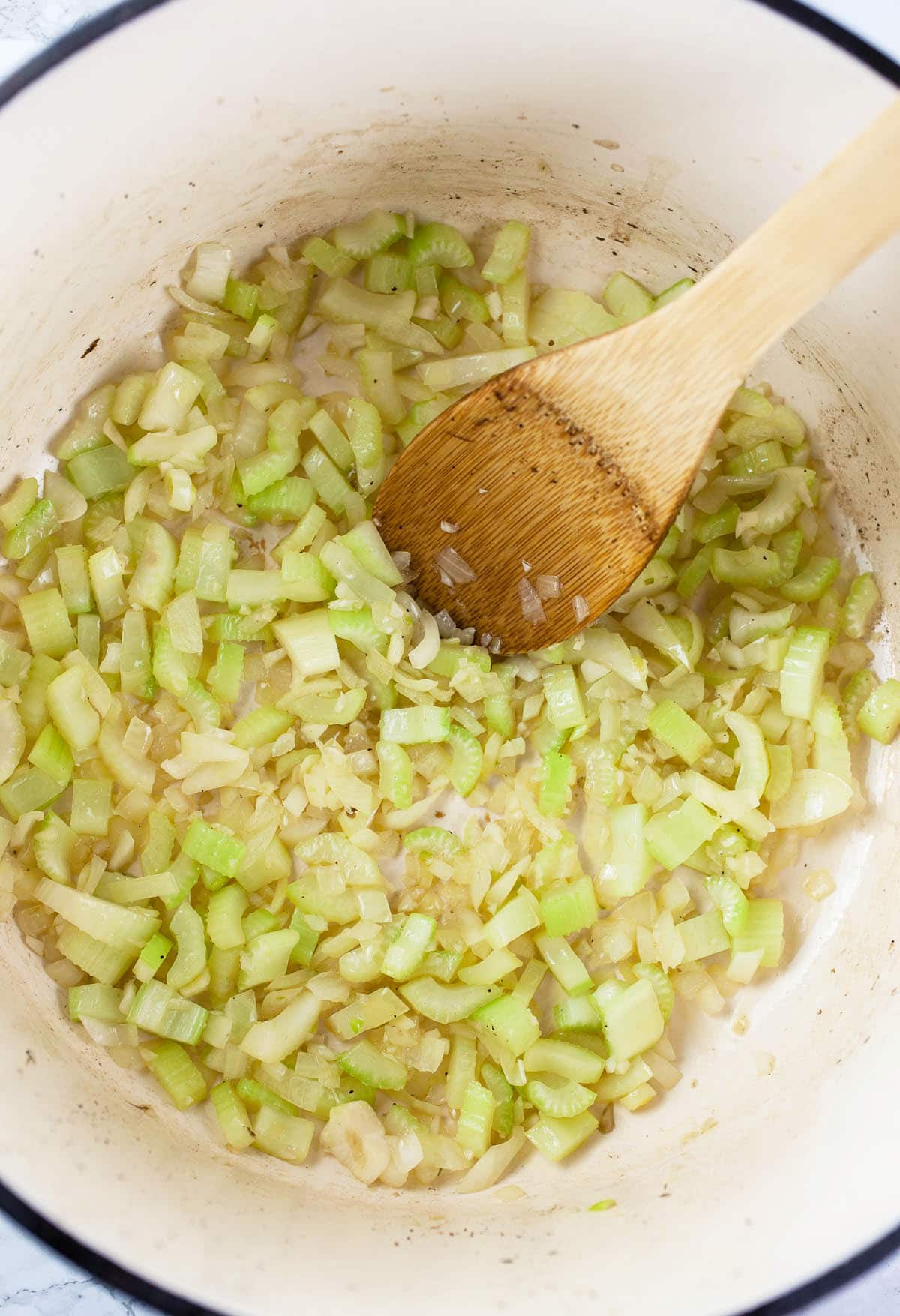 Garlic, onions, and celery sautéed in white Dutch oven.