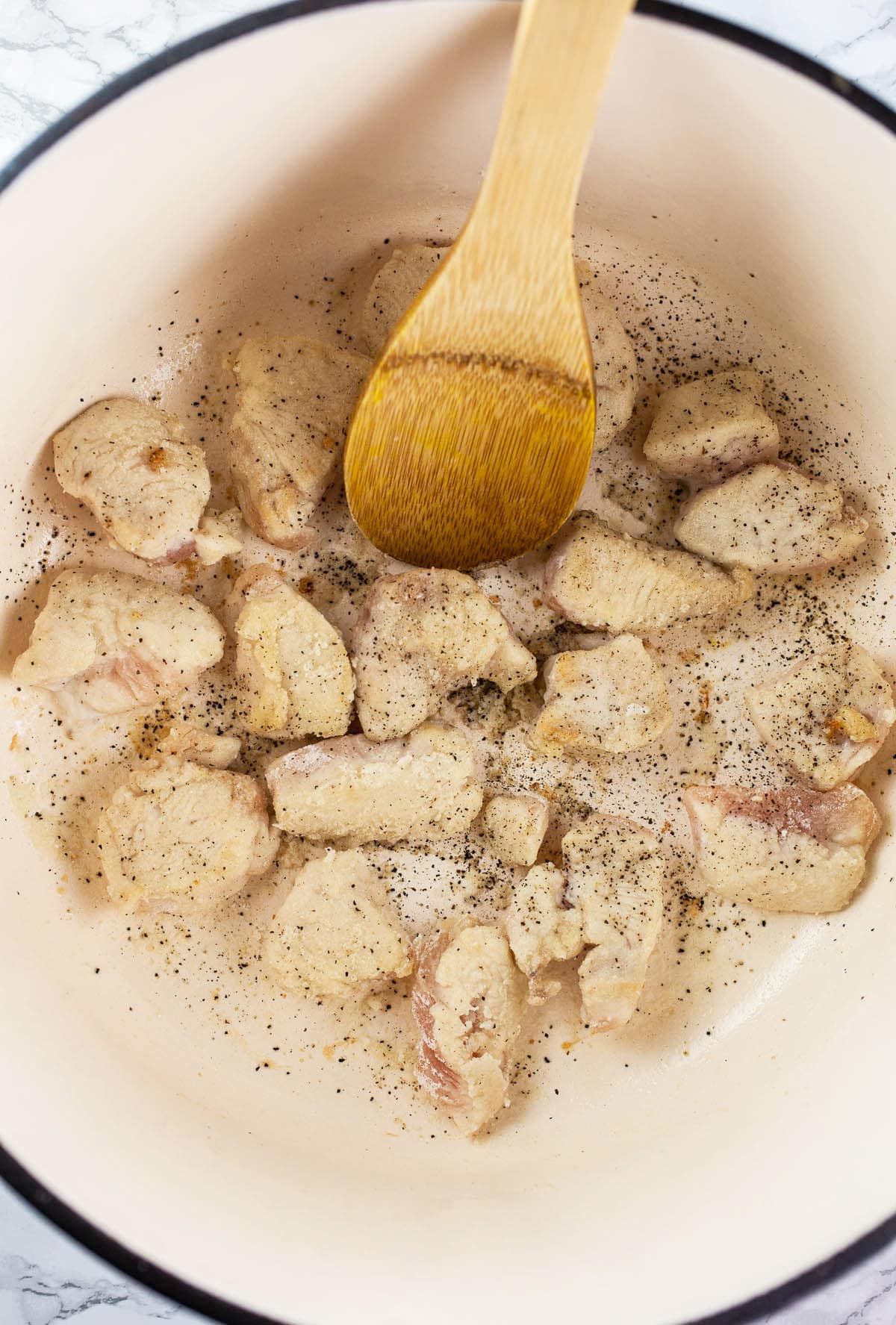 Flour coated diced chicken sautéed in Dutch oven.