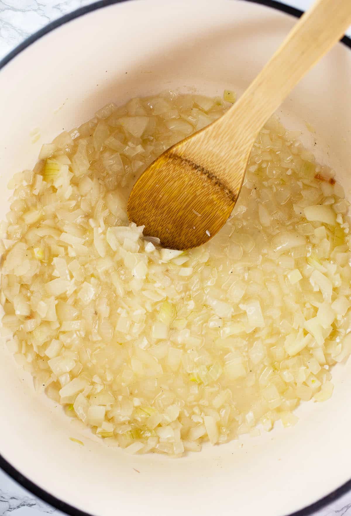 Garlic and onions sautéed with white wine in Dutch oven.