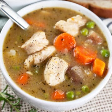 Gluten free chicken stew in small white bowl with spoon.