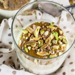 Pistachio panna cotta with chopped pistachios in glass.