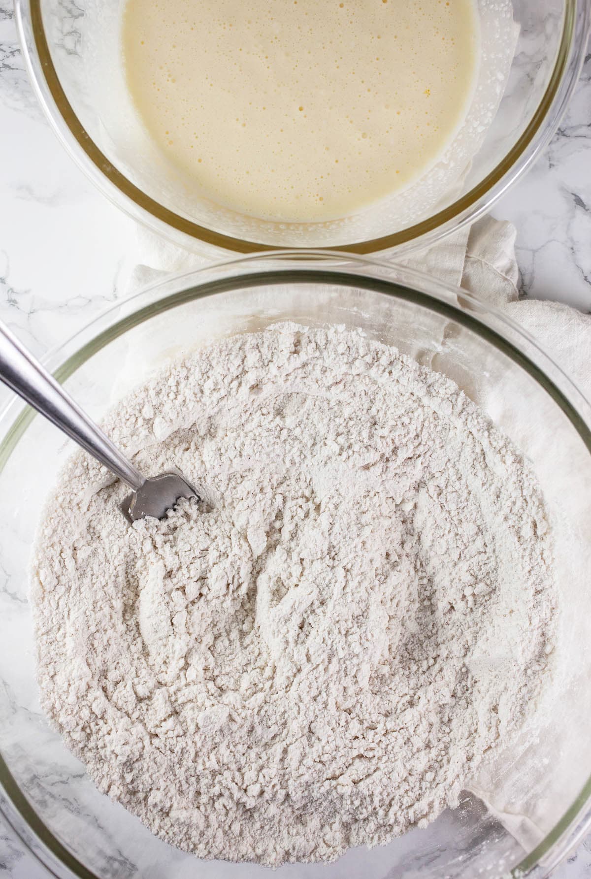 Dry and wet scone ingredients in two separate glass bowls.