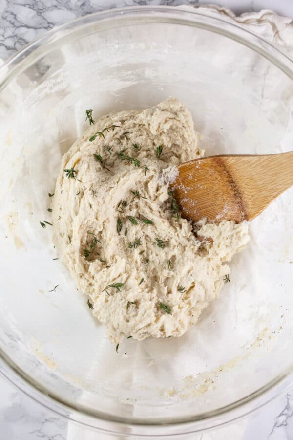 Dumpling mixture with thyme in glass bowl.