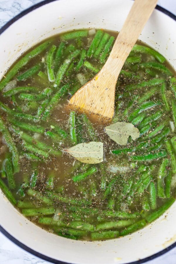 Uncooked vegetable stew in white Dutch oven.