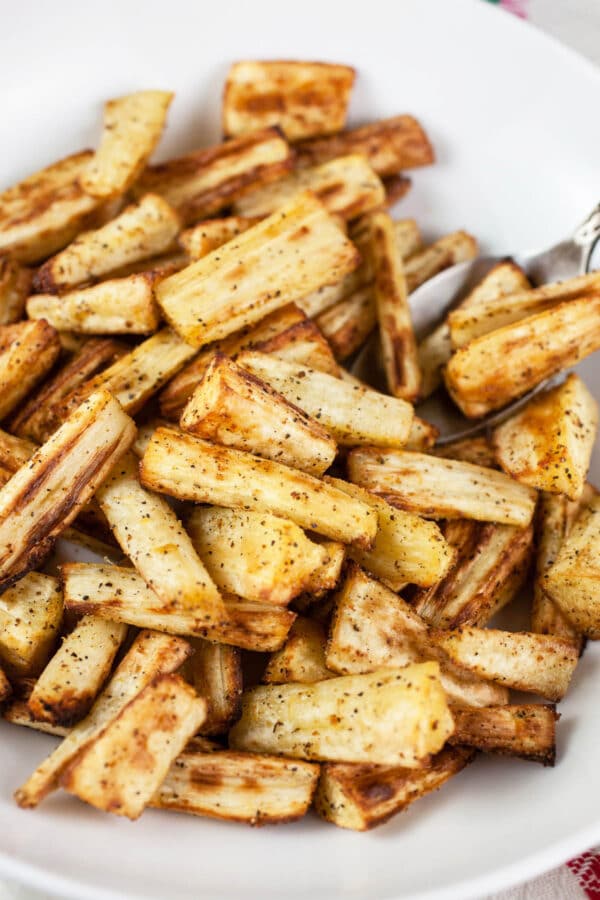 Roasted parsnips in white bowl.