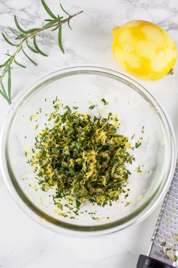 Lemon rosemary gremolata in small glass bowl with zester.