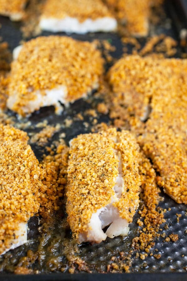 Baked cod fillets with Panko breadcrumb topping on baking sheet.