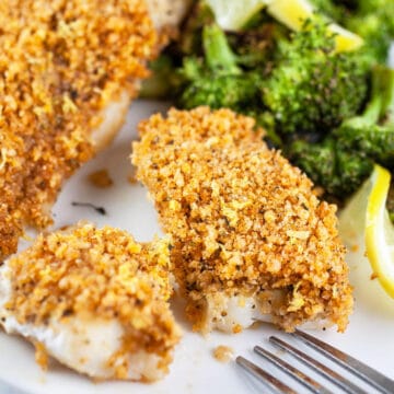 Panko baked cod with breadcrumb topping on white plate with broccoli.