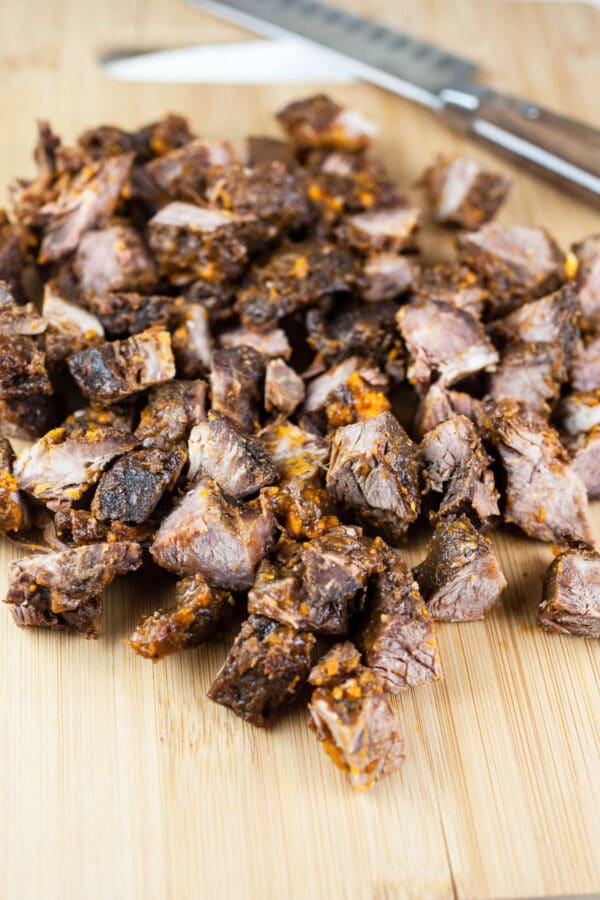 Diced beef short ribs on wooden cutting board.