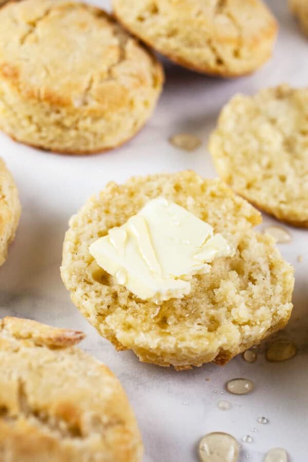 Gluten Free biscuits cut in half with butter and drizzled honey.