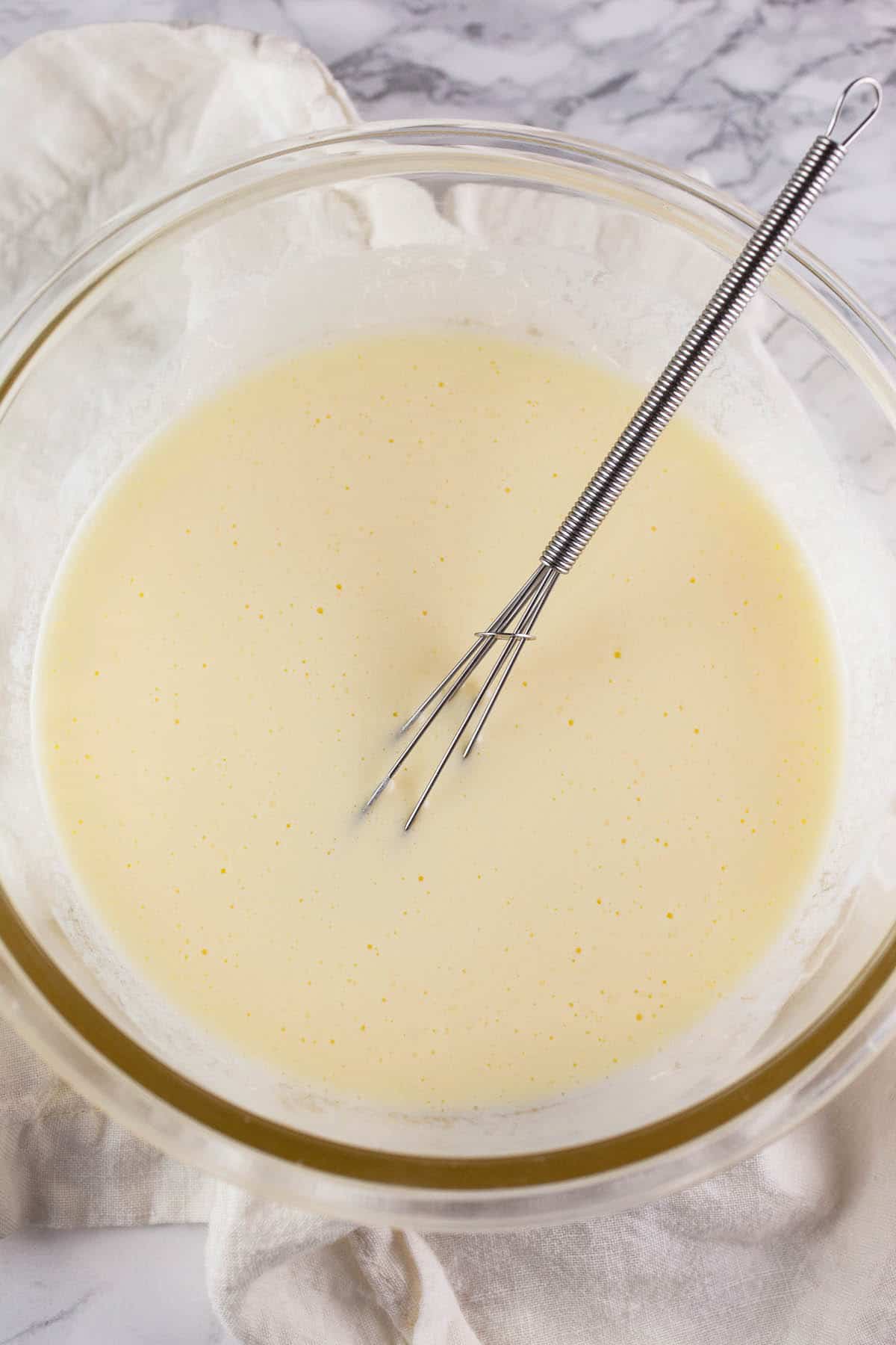 Wet ingredients in small glass bowl with whisk.