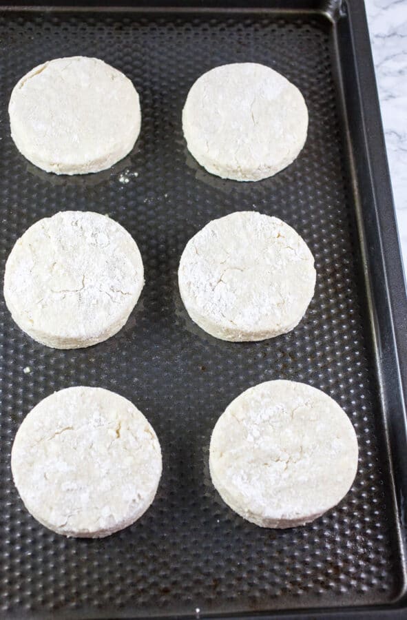 Unbaked biscuits on metal baking sheet.