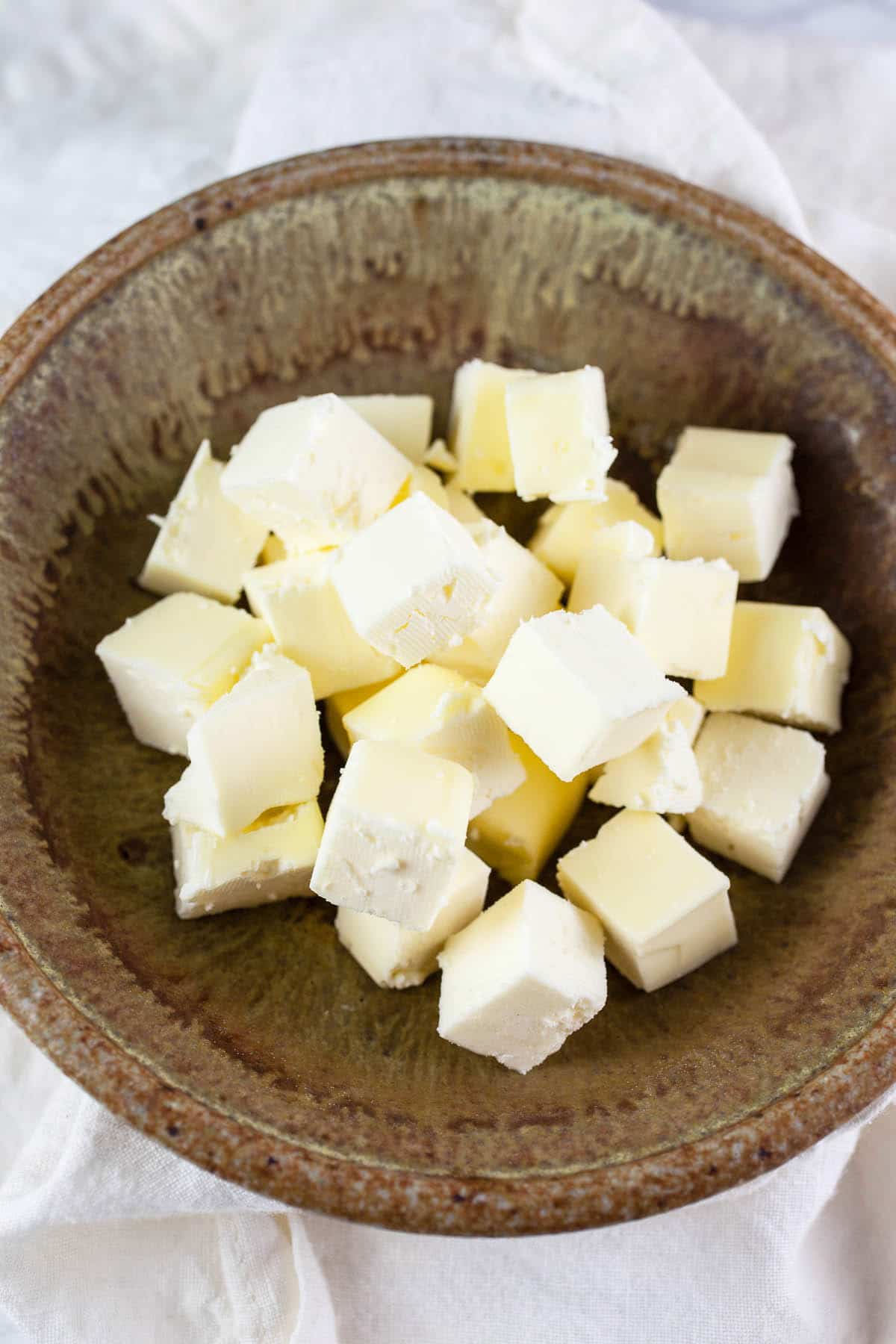 Frozen butter cubes in small ceramic bowl.