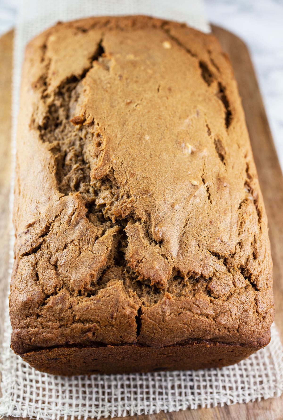 Loaf of coffee banana bread on wood board.