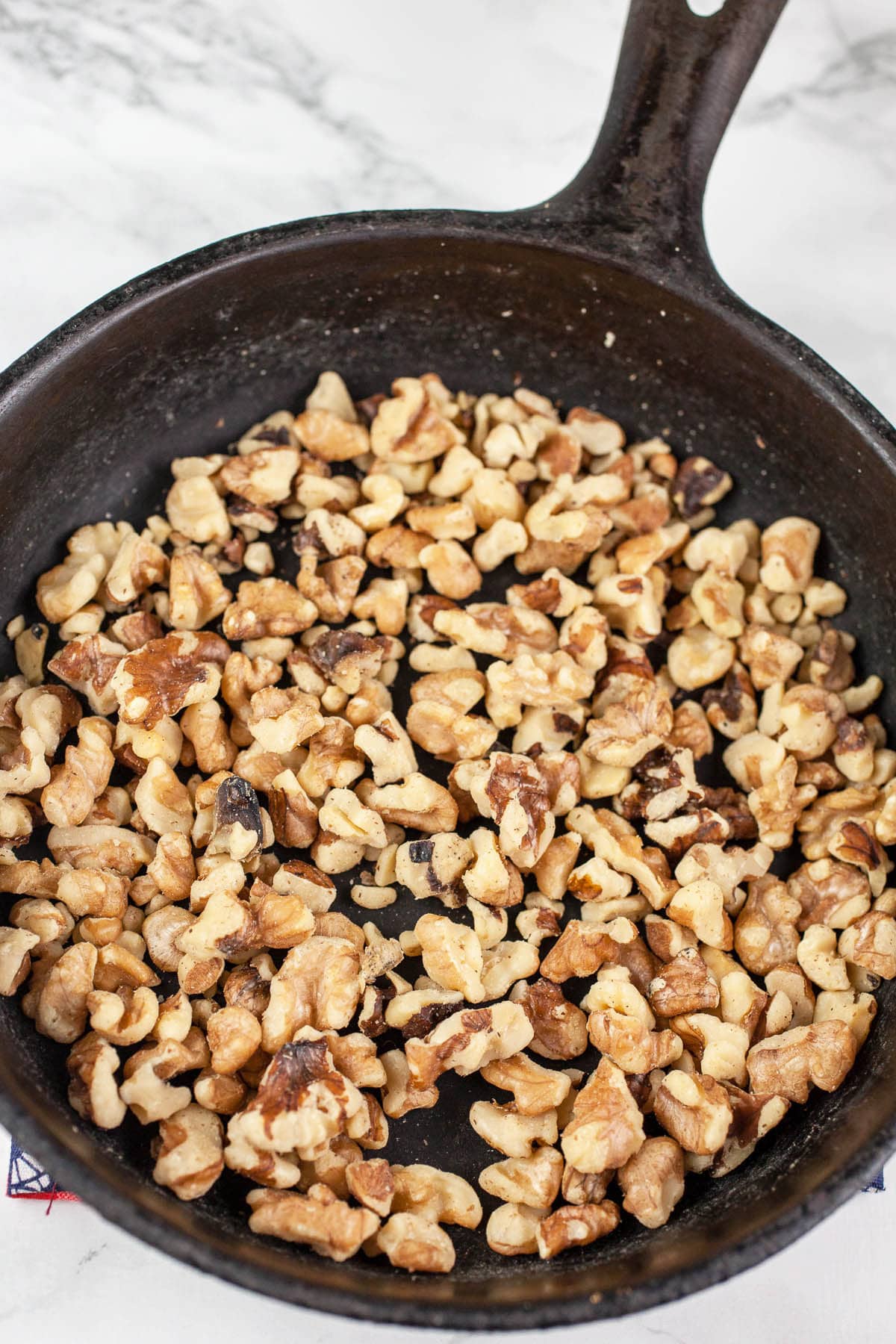 Toasted chopped walnuts in small cast iron skillet.