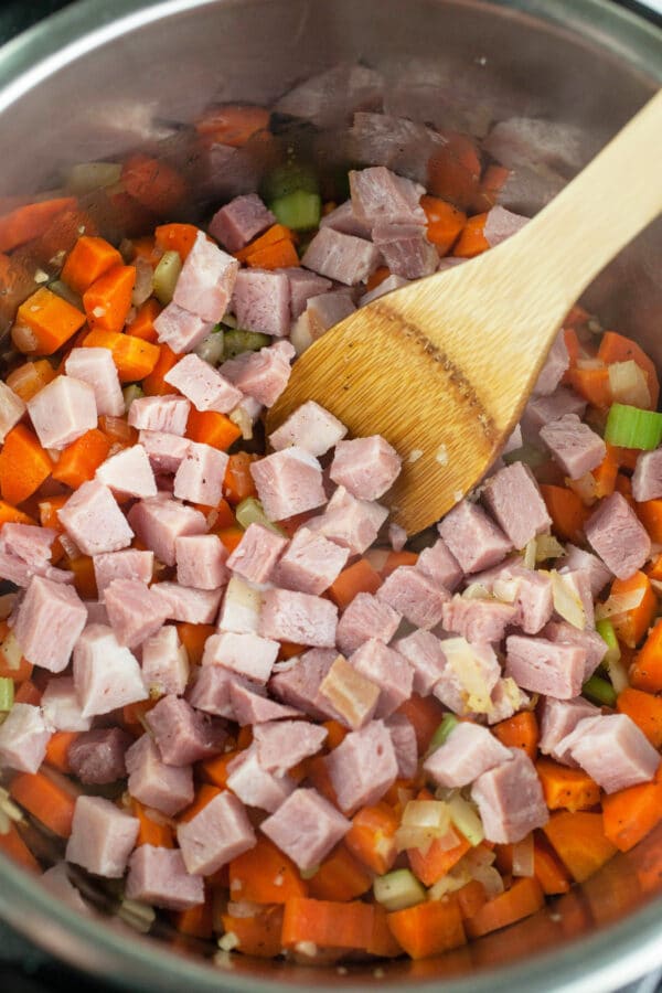 Garlic, onions, celery, carrots, and diced ham sautéed in Instant Pot.