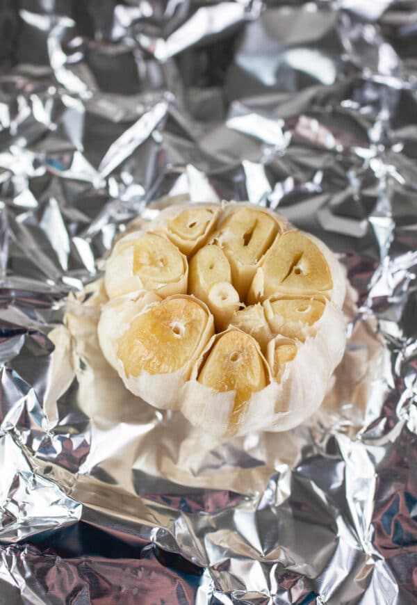 Roasted garlic bulb on piece of tinfoil.