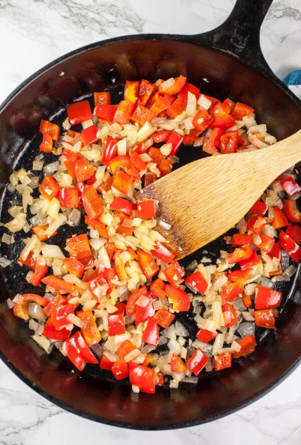 Garlic, onions, and diced red bell peppers sautéed in cast iron skillet.