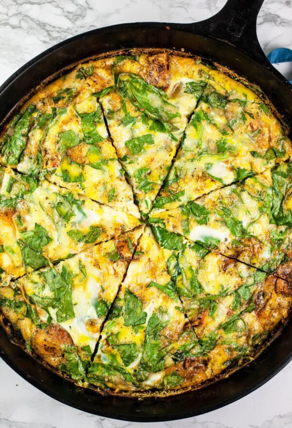 Southwest frittata cut into slices in cast iron skillet.