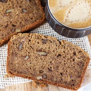 Slices of coffee banana bread on wooden board with cup of coffee.