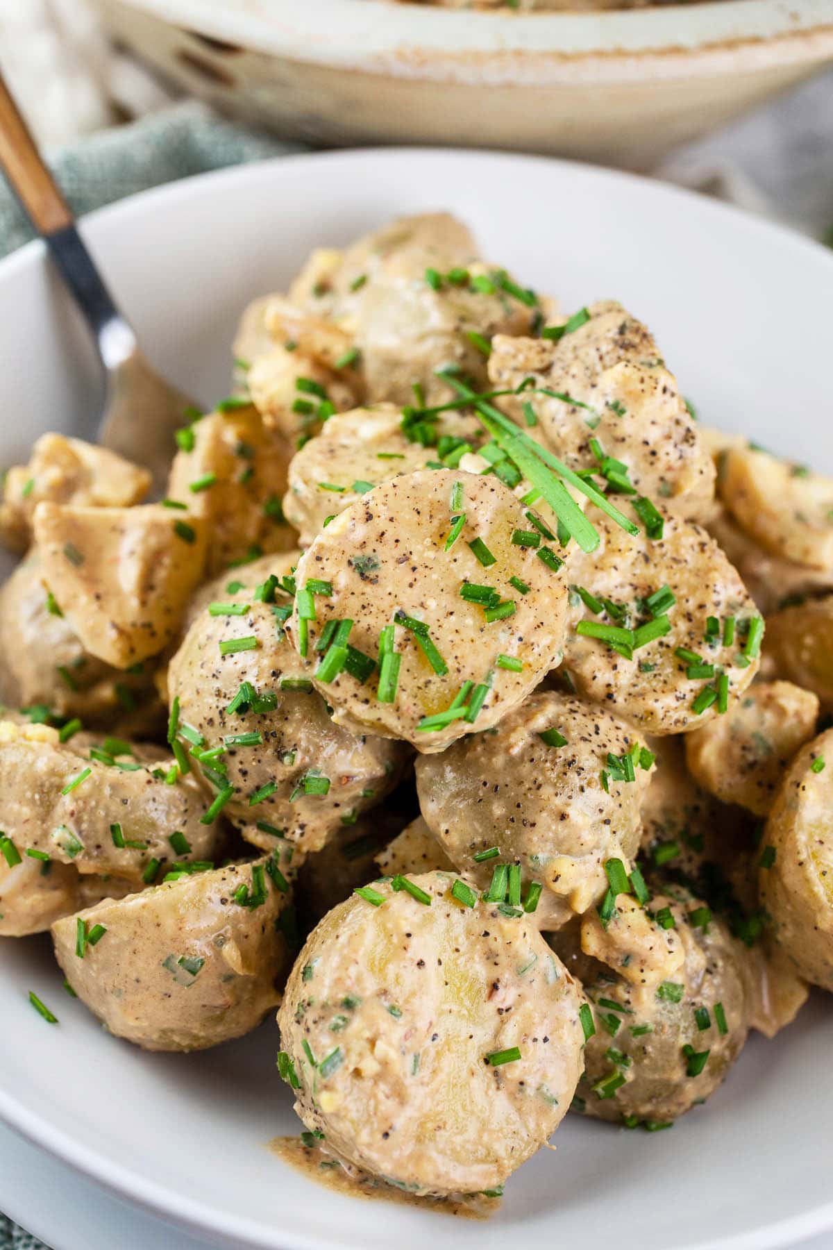 Chipotle potato salad in white bowl with fork.