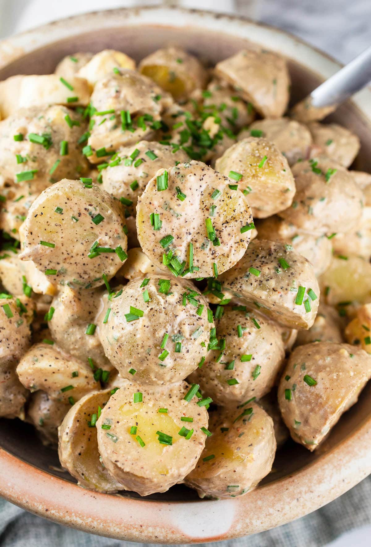 Chipotle potato salad with chives in ceramic bowl.