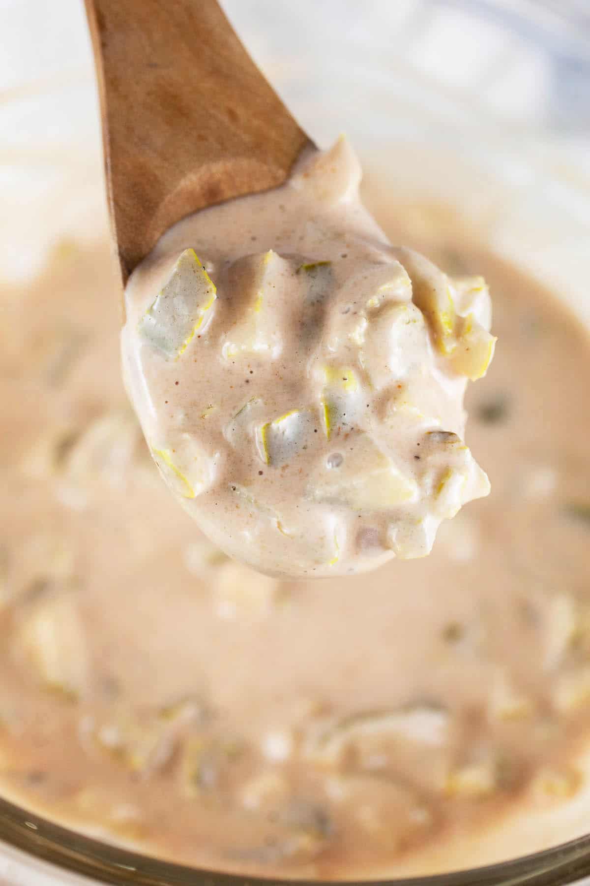 Spoonful of jalapeno burger sauce lifted from small glass bowl.