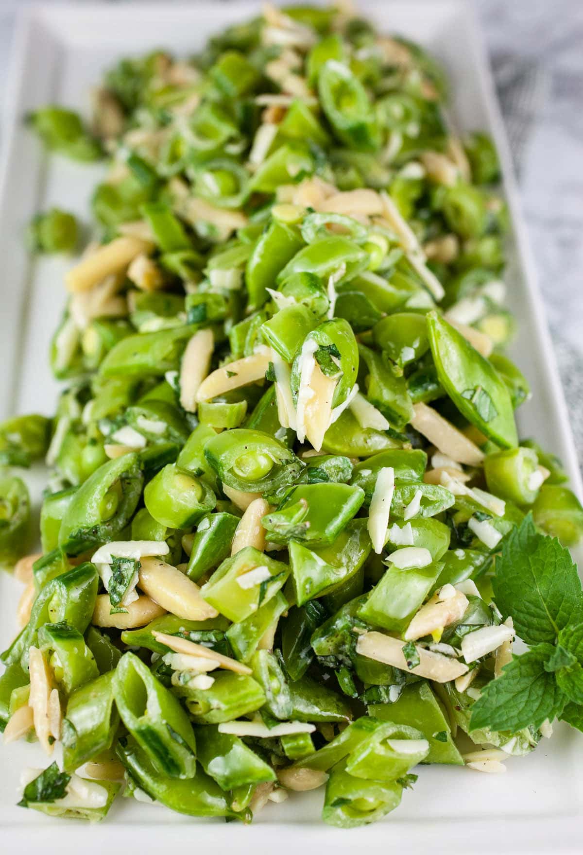 Fresh pea mint salad on white serving platter.