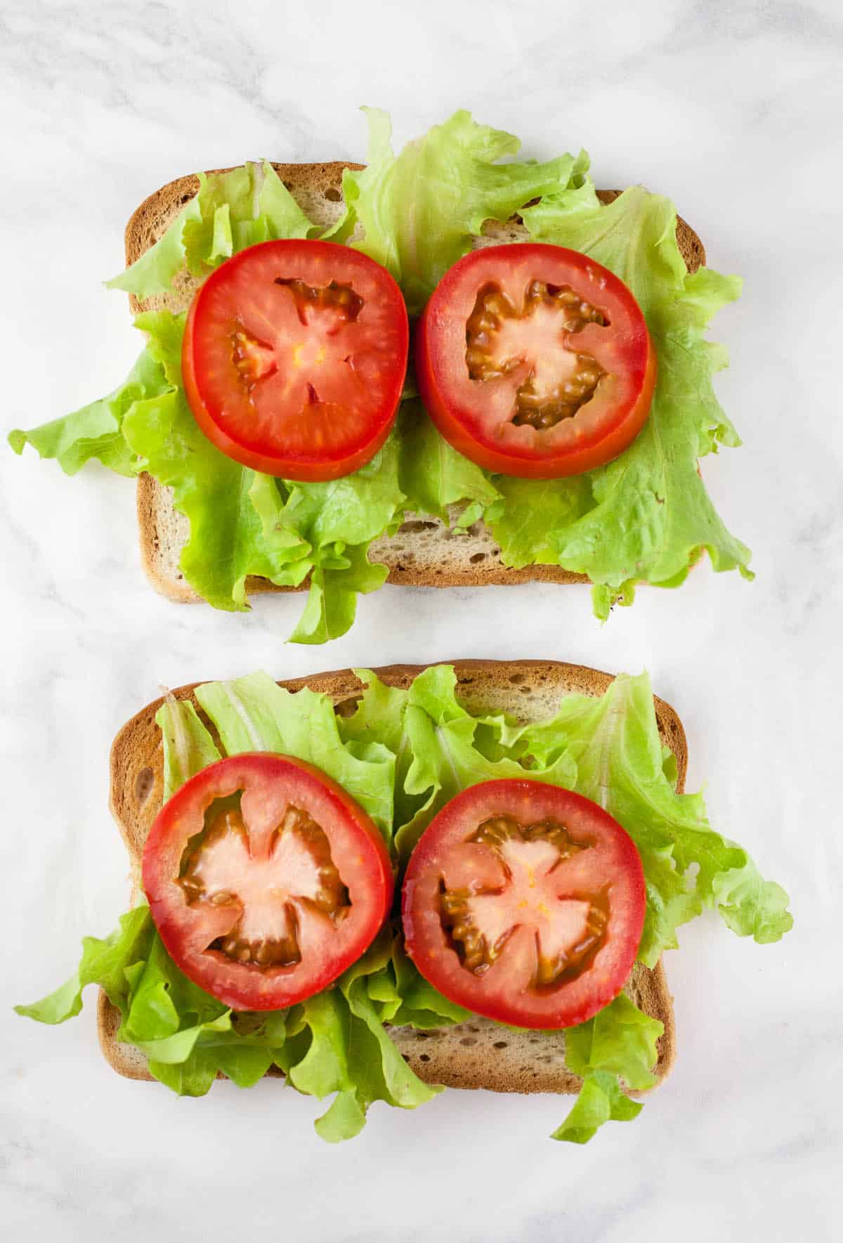 Tomato slices and lettuce on toasted bread.