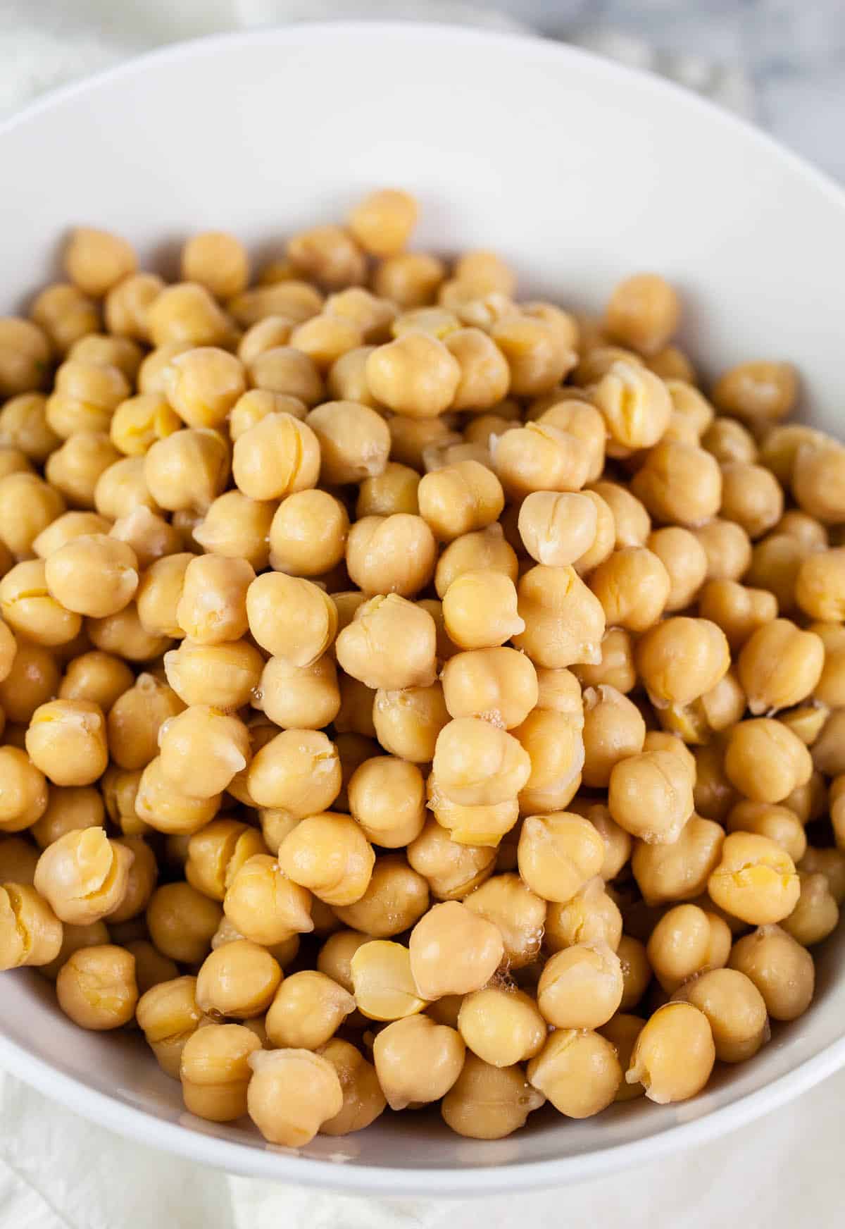 Rinsed canned chickpeas in white bowl.