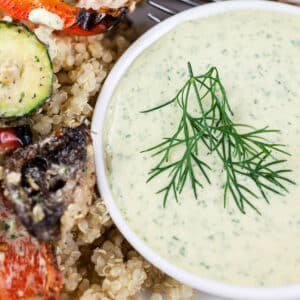 Lemon herb tahini sauce in small white bowl with fresh dill.