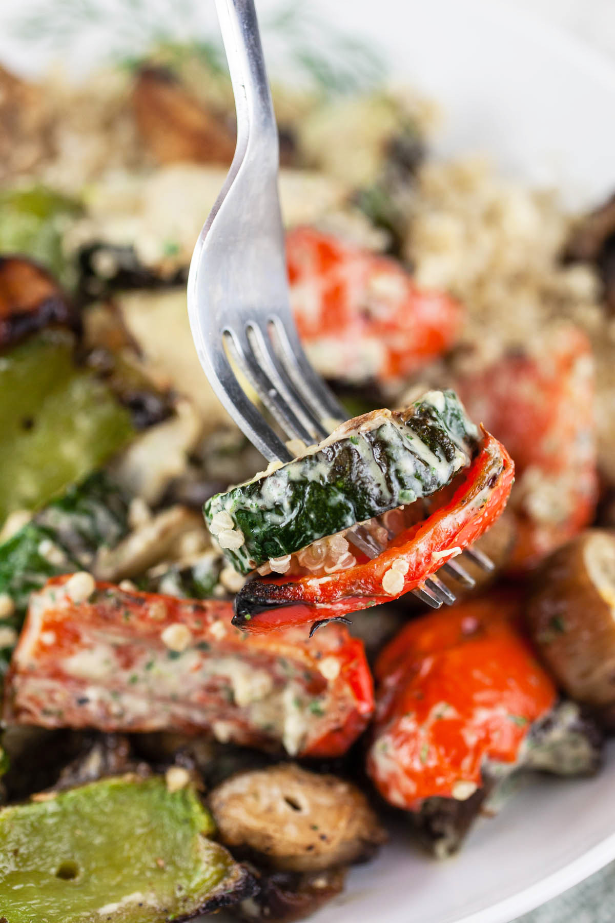 Forkful of vegetables lifted from bowl of roasted vegetable salad.