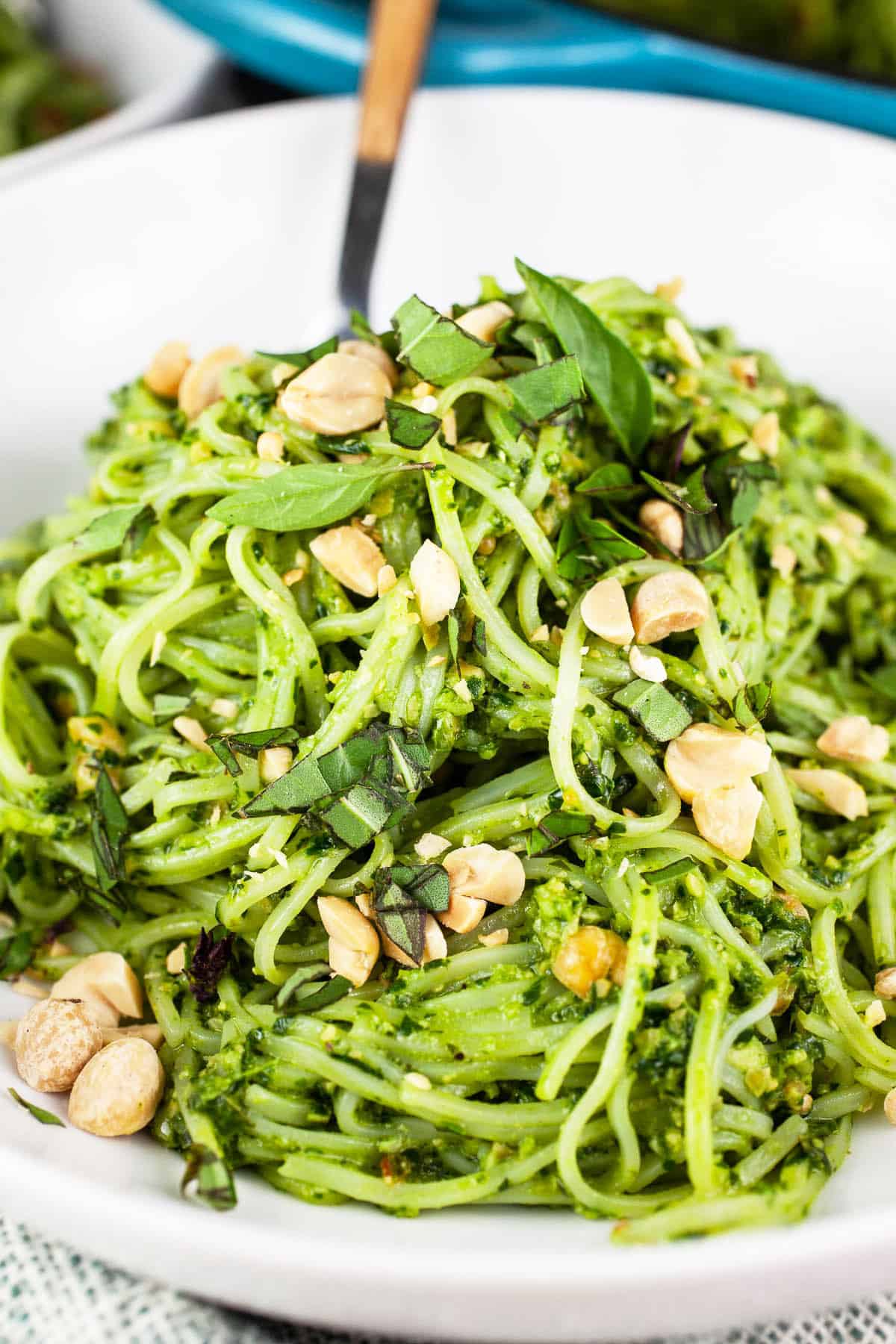 Rice noodles tossed with Thai basil pesto sauce in white bowl.