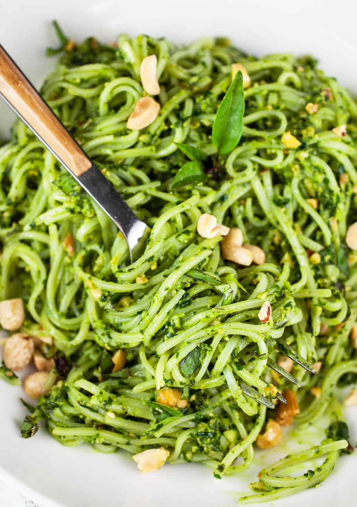 Thai pesto rice noodles in white bowl with fork.