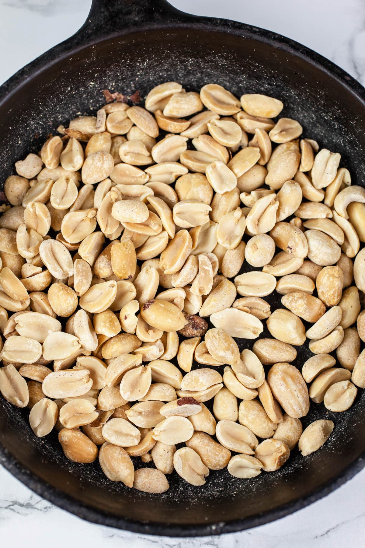 Toasted peanuts in small cast iron skillet.