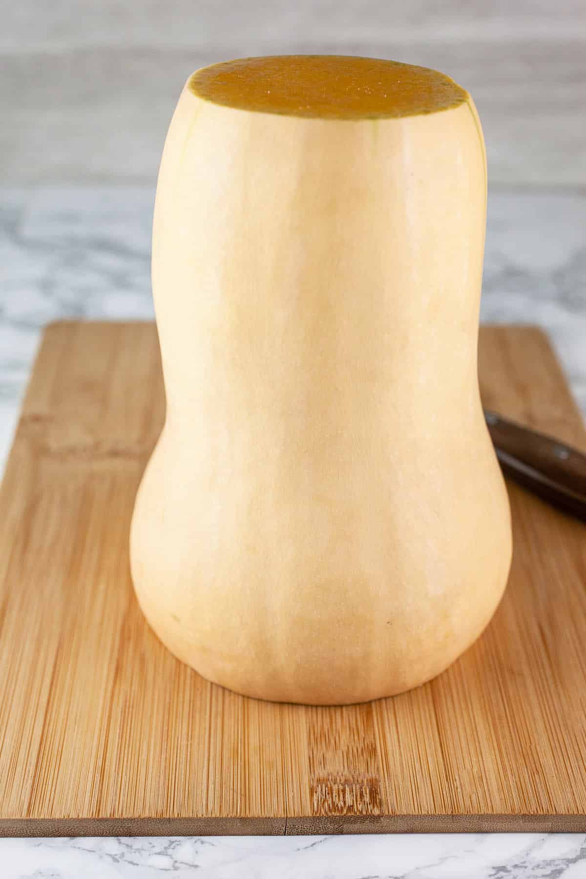 Butternut squash on wooden cutting board.