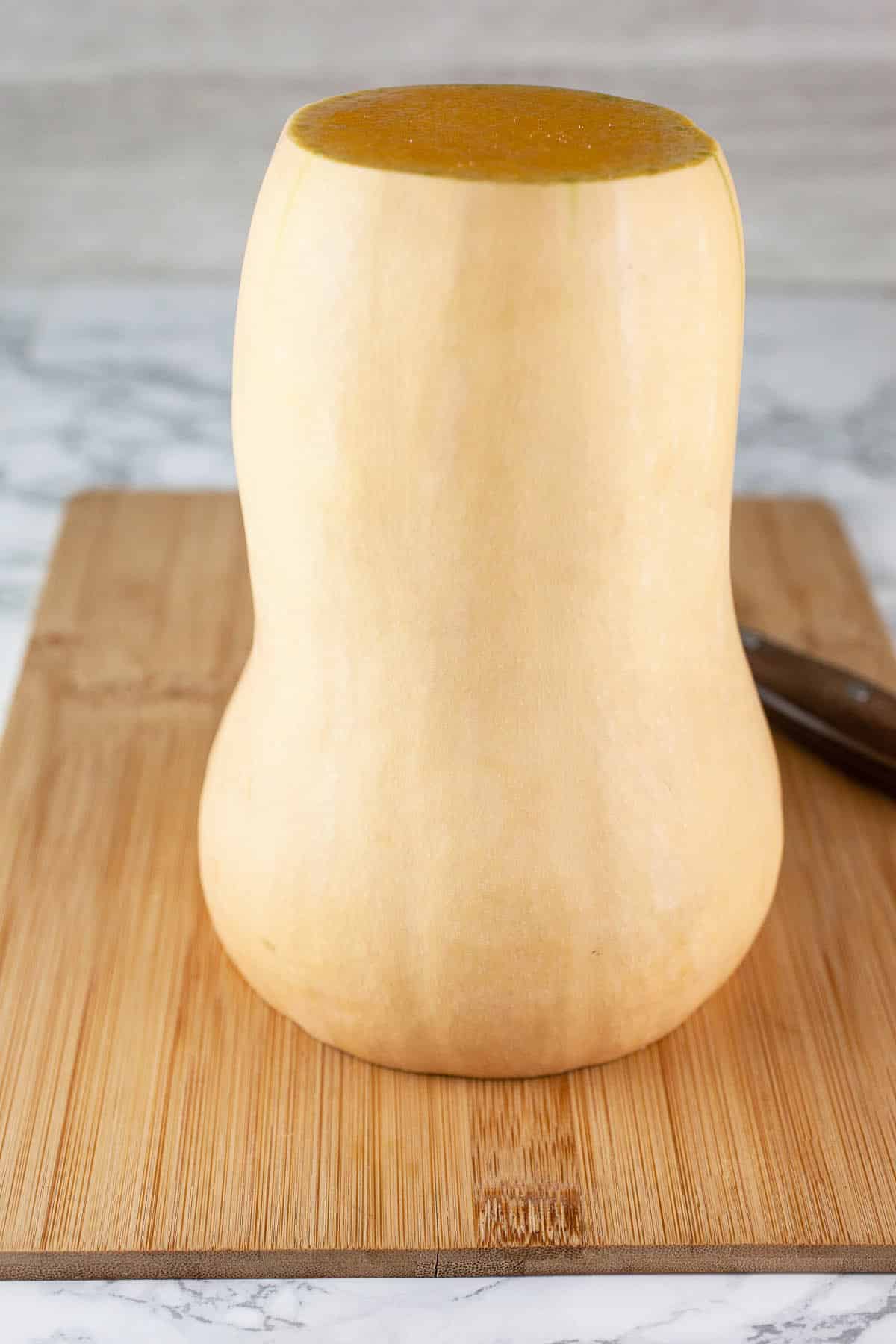 Butternut squash on wooden cutting board.