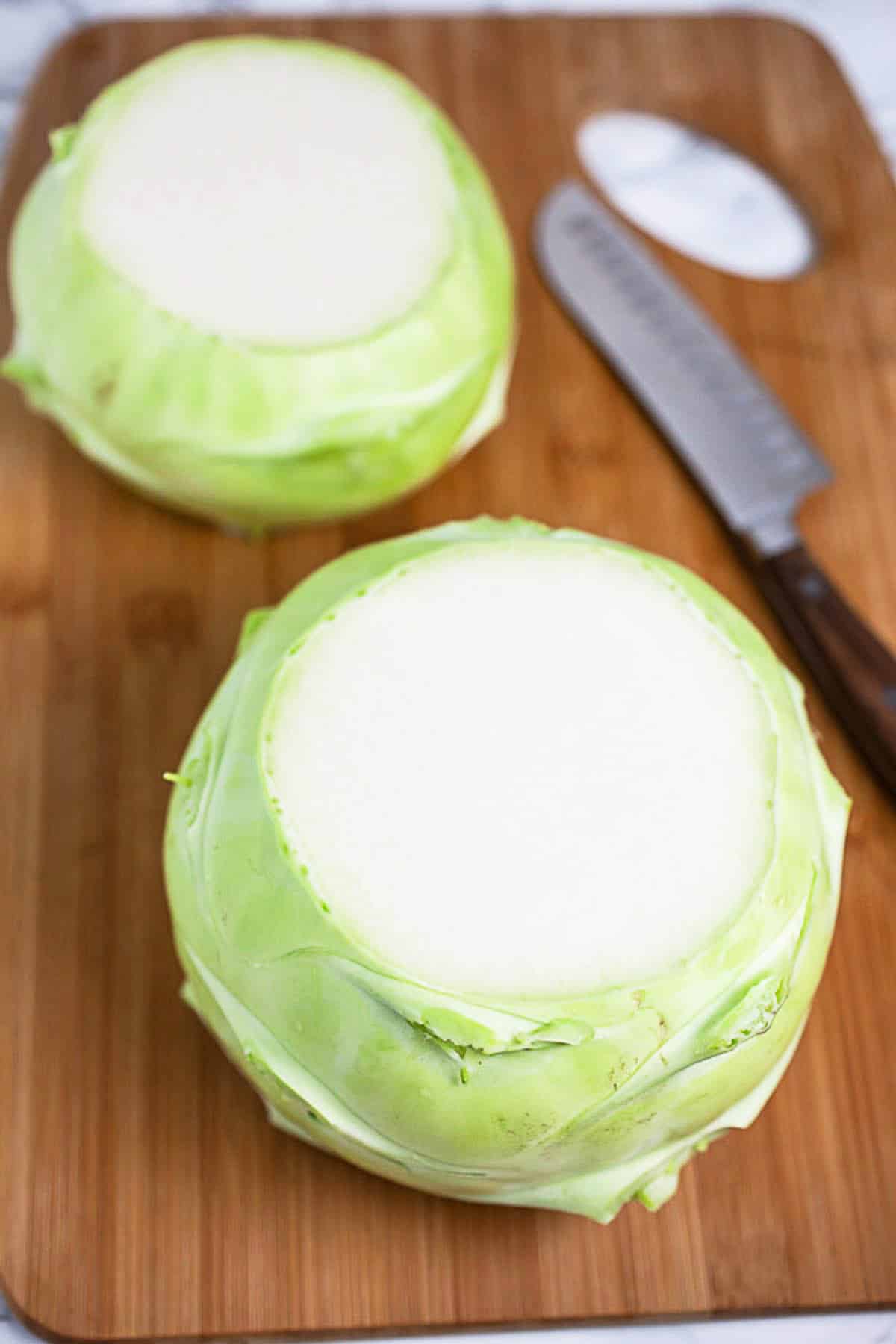 Kohlrabi with top and bottom removed on wooden cutting board.