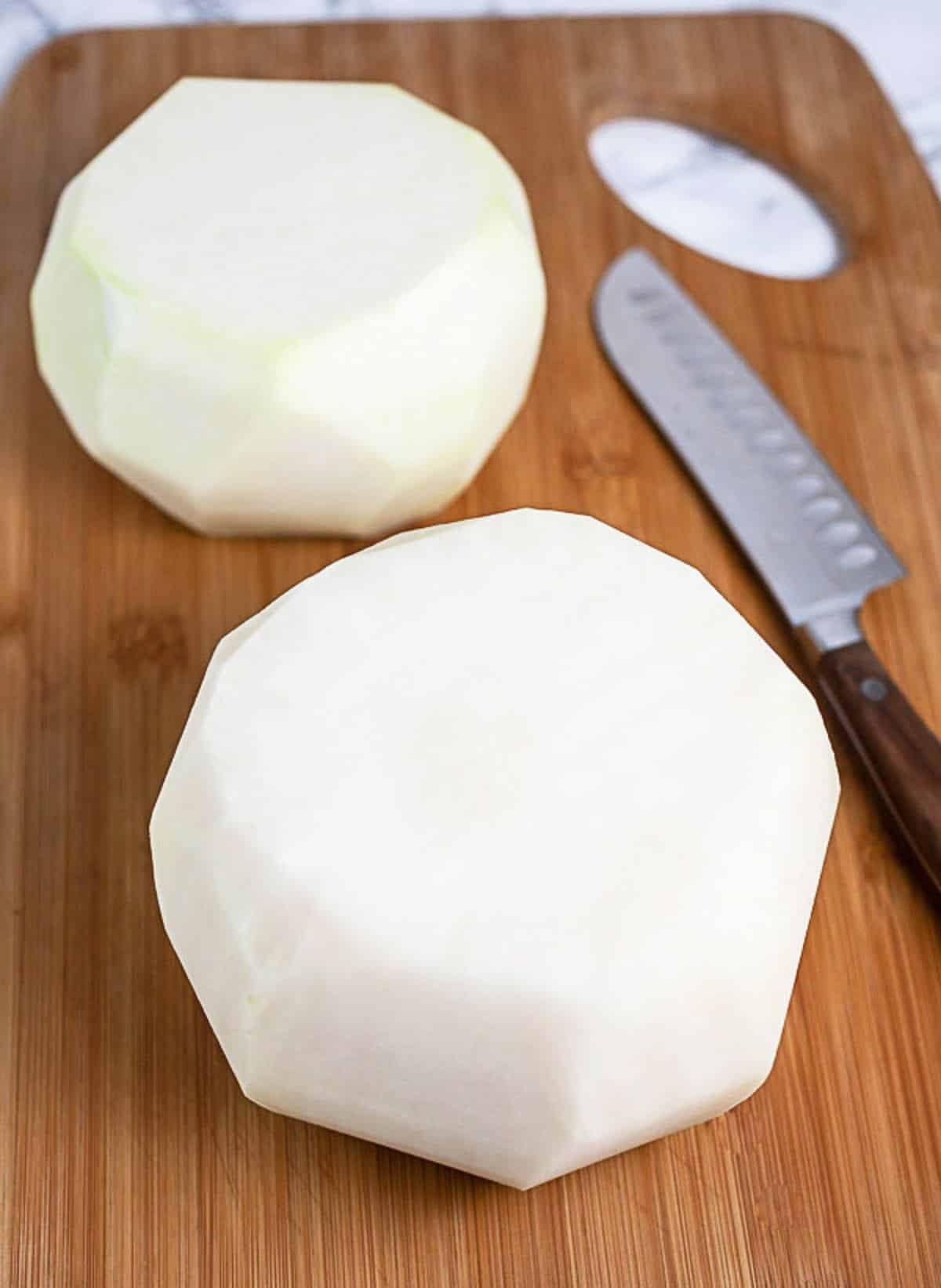 Peeled kohlrabi on wooden cutting board.