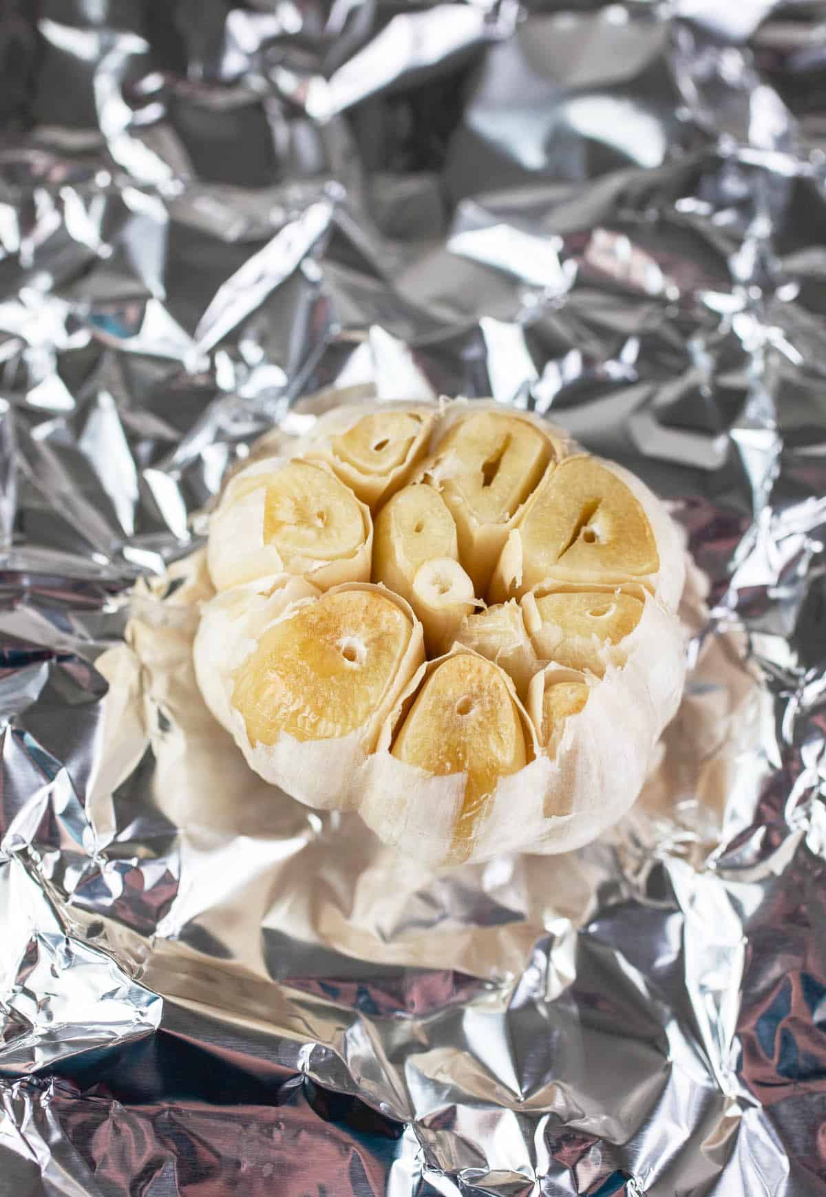 Roasted head of garlic on tinfoil.
